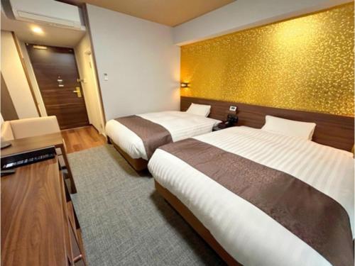 a hotel room with two beds and a mirror at Second Inn Hana Hotel Hanazono Inter - Vacation STAY 40299v in Fukaya