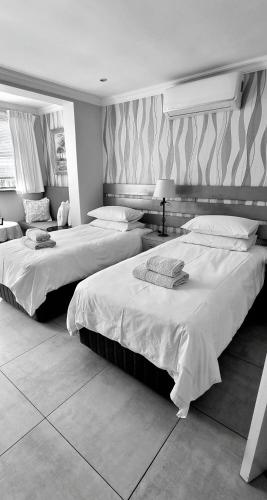 two beds in a hotel room with at Studio on Albert, Hout Bay in Hout Bay