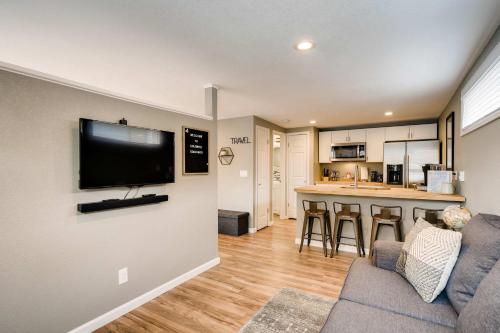 a living room with a couch and a tv on a wall at Olympic Studio - Workcation Hot Tub 4K Roku in Colorado Springs