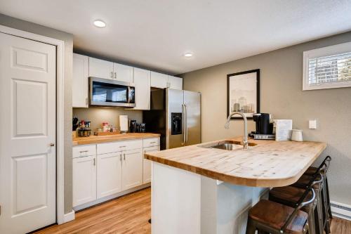 a kitchen with white cabinets and a wooden counter top at Olympic Studio - Workcation Hot Tub 4K Roku in Colorado Springs