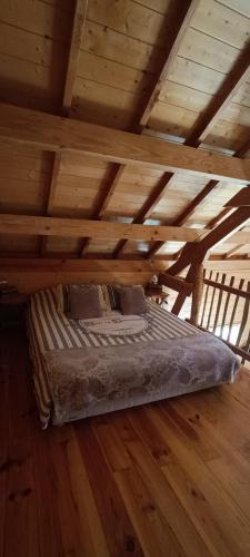 un lit dans une chambre avec un plafond en bois dans l'établissement Cabanes des Pins Sylvestres Boréon, à Saint-Martin-Vésubie