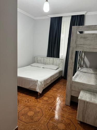 a bedroom with two bunk beds and a wooden floor at Nika house in Ureki