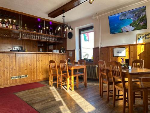 a bar with wooden tables and chairs in a restaurant at Privatzimmer Mama in Tresdorf