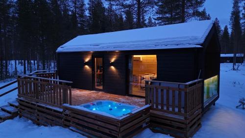 a log cabin with a hot tub in the snow at Hossaville Luxe West Lake Cabin in Hossa