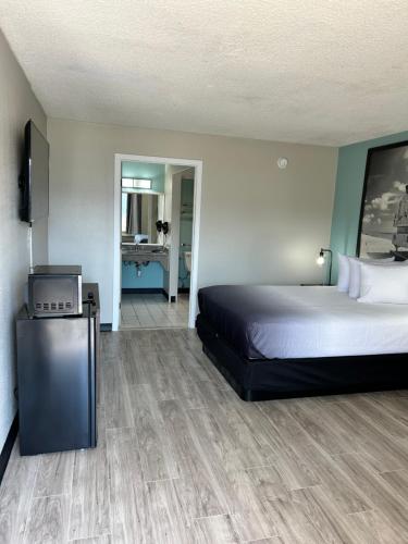 a bedroom with a bed and a television and a bathroom at Super 8 by Wyndham Ocala I-75 in Ocala