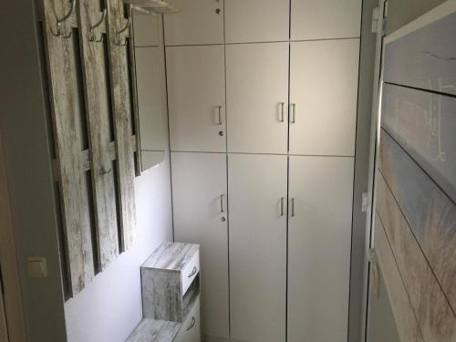 a bathroom with white cabinets and a window at Ferienwohnung Strandidyll in Strandnähe in Trassenheide