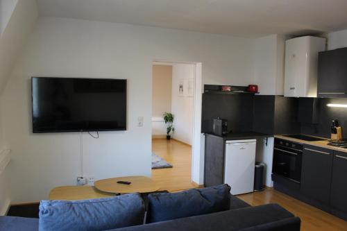 a living room with a couch and a table in a kitchen at Deluxe Urban Stay in Linz
