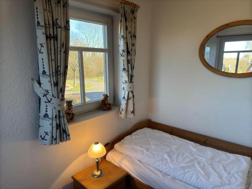 a bedroom with a bed and a window at gemütliche Doppelhaushälfte in Burhave in Burhave