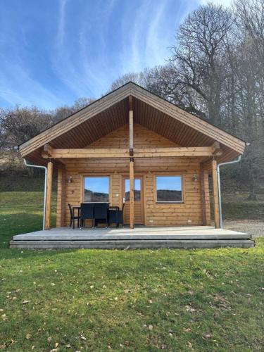 une cabane en rondins avec une table au milieu dans l'établissement Le Chalet de Lintignat, à Peyrat-le-Château