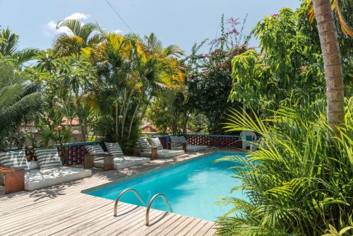 a swimming pool in a yard with palm trees at Vila Anauá in Japaratinga