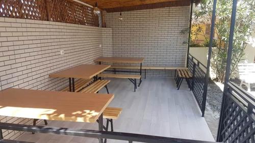 a patio with tables and benches on a brick wall at Nika house in Ureki