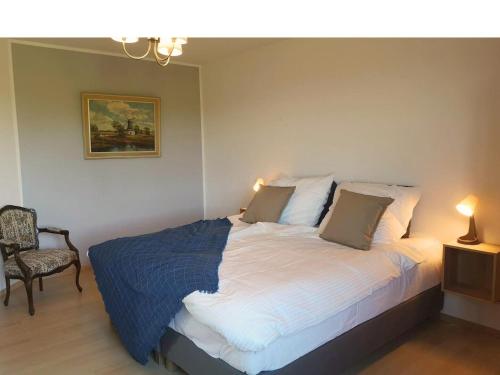 a bedroom with a bed and a chair and a painting at Fischerhus in Rieseby