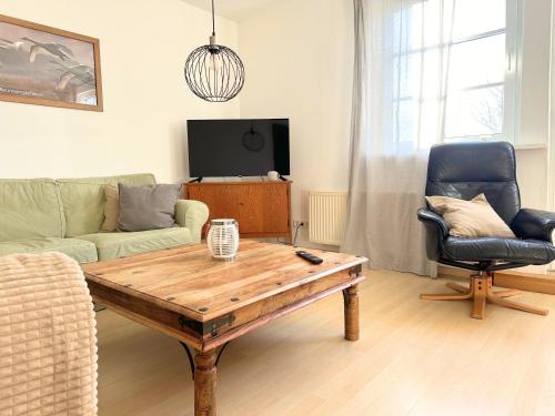 a living room with a table and a couch and a chair at Fischerhus in Rieseby
