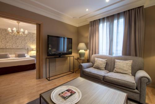 a living room with a couch and a tv and a bed at Vincci Lys in Valencia