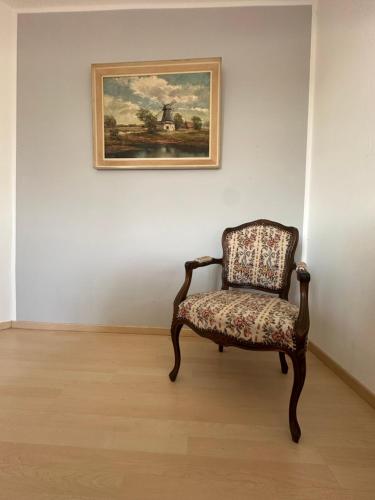 a chair sitting in front of a painting on a wall at Fischerhus in Rieseby