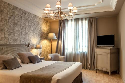 a hotel room with a bed and a television at Vincci Lys in Valencia