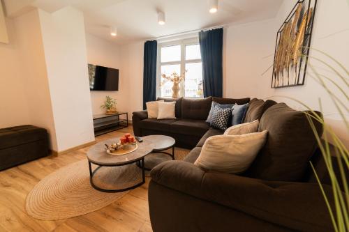 a living room with a couch and a table at Domek z trzema sypialniami - Dom Morsa Mielno in Mielno