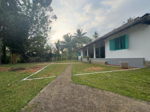 a house with a grass yard next to a building at Serendib Veranda in Galle