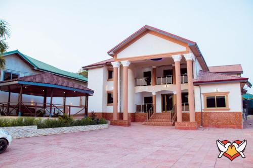 a house with a pavilion in front of it at Whispering Hearts Guest House in Bortianor