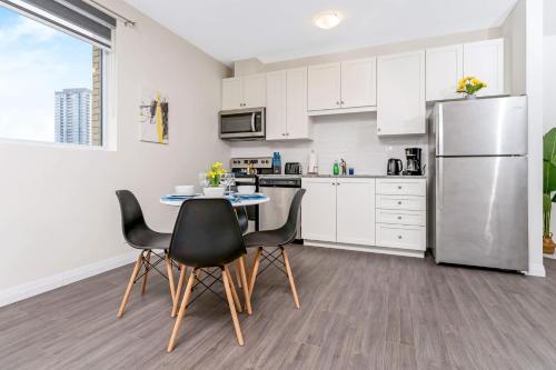 a kitchen with a table and chairs and a refrigerator at DT High Rise Condo w Private Patio and View in Kitchener
