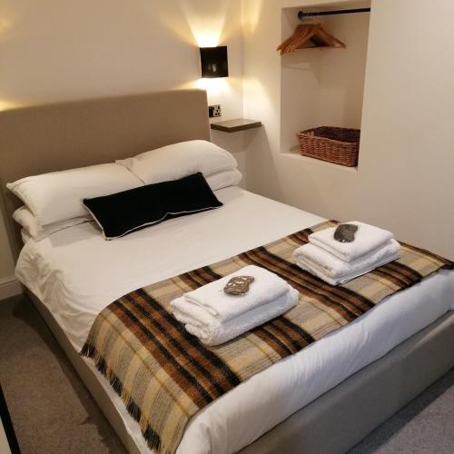 a bedroom with a bed with two towels on it at The Burrow in Penrith
