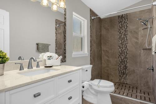 een badkamer met een toilet, een wastafel en een douche bij 1st Animatronic Dinosaur Villa in Orlando