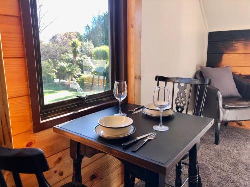 a table with two wine glasses on top of it at The Mountain View Studio in Rangataua