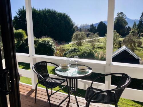 a table and two chairs on a balcony with a view at The Mountain View Studio in Rangataua