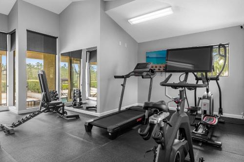 a room with a gym with a treadmill and a tv at Florida Getaway - Renovated TownHome by Disney! in Orlando