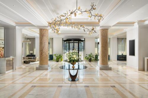 a lobby with a table and a chandelier at InterContinental Athenee Palace Bucharest by IHG in Bucharest