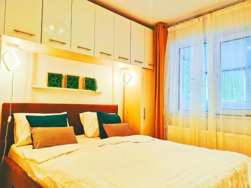 a bedroom with a large bed and a window at Baneasa Apartment Residence in Bucharest