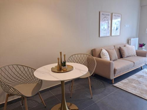 a living room with a couch and a table and chairs at Elegant City Center Apartment in Serres