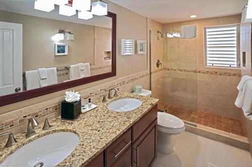 a bathroom with a sink and a toilet and a mirror at Secret Harbour Beach Resort in St Thomas