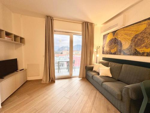 a living room with a couch and a large window at Apartment Prestige in Finale Ligure