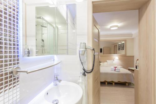 a bathroom with a sink and a shower and a bed at Villa Anna - Noclegi Rooms - FREE parking, taras, 1500m do Starówki in Gdańsk