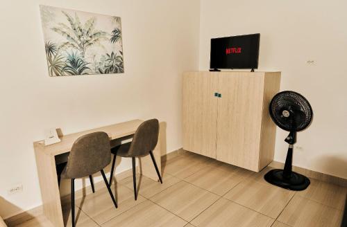 a room with a desk with chairs and a fan at Apartahotel Poblado-Aguacatala in Envigado