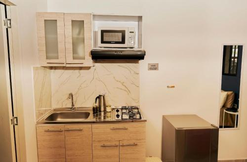 a small kitchen with a sink and a microwave at Apartahotel Poblado-Aguacatala in Envigado