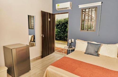 a bedroom with a bed and a window and a door at Apartahotel Poblado-Aguacatala in Envigado