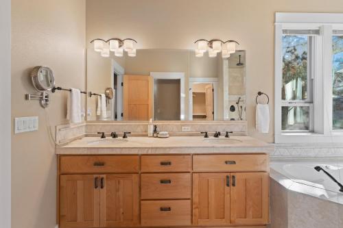 a bathroom with two sinks and a large mirror at Lucy Lou 30 Day Minimum in Bend