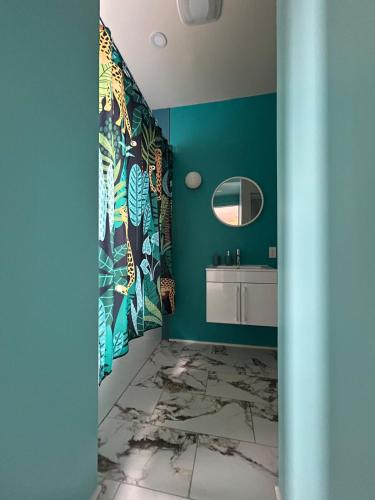 a bathroom with green walls and a sink and a mirror at Bright and spacious appartment in Montreal
