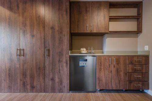 メデジンにあるElegant Space in El Tesoro Recharge in Comfort 308のキッチン(木製キャビネット、食器洗い機付)