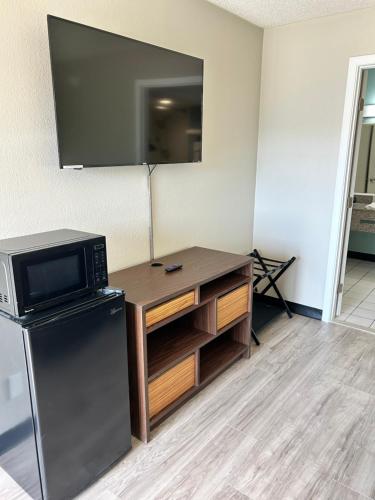 a kitchen with a desk with a microwave and a tv at Super 8 by Wyndham Ocala I-75 in Ocala