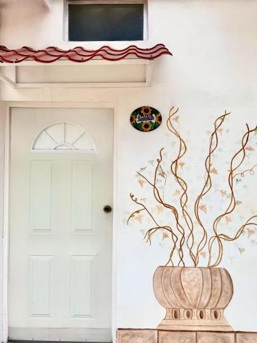 a front door of a house with a painting on the wall at La Casita Inn Bustamante in Bustamante