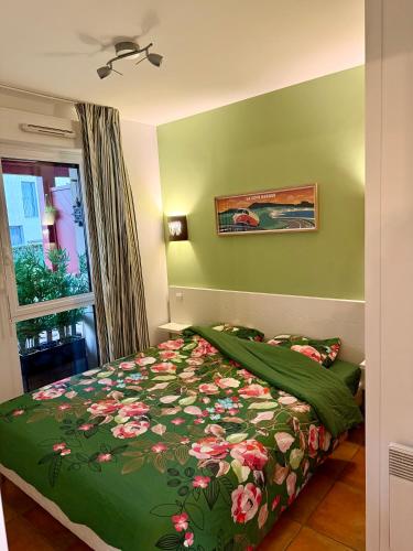 - une chambre avec un lit doté d'une couette verte et d'une fenêtre dans l'établissement Luzea, Domaine Iratzia, à Saint-Jean-de-Luz