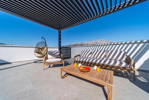 a patio with a couch and a table on a roof at Penthouse apartment Optimum in Korčula