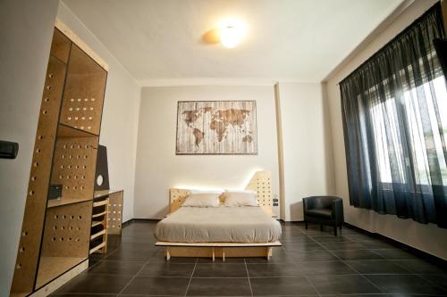 a bedroom with a bed and a chair and a window at Factory Design in Naples