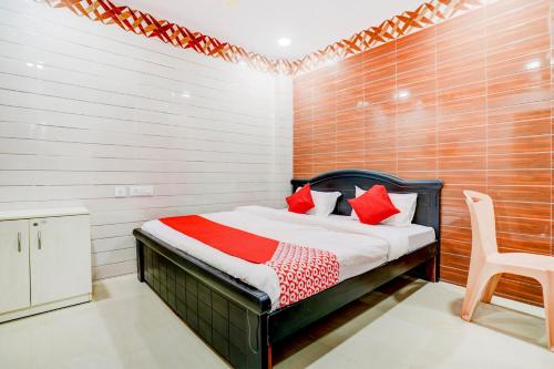 a bedroom with a bed and a chair in it at Hotel O Aroma Classic Near Nampally Main Railway station in Hyderabad