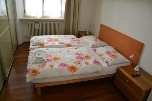 sypialnia z 2 łóżkami z kwiatami w obiekcie Guesthouse Bauzanum Streiter w mieście Bolzano