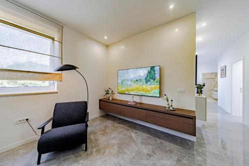 a living room with a chair and a television on a wall at Penthouse apartment Optimum in Korčula