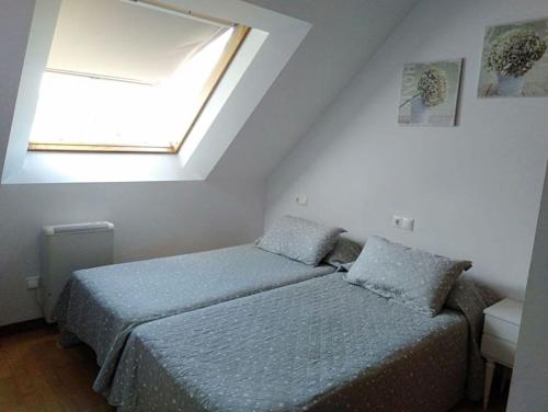 ein Schlafzimmer mit einem Bett und einem Dachfenster in der Unterkunft Barraña Boiro Mar in Boiro
